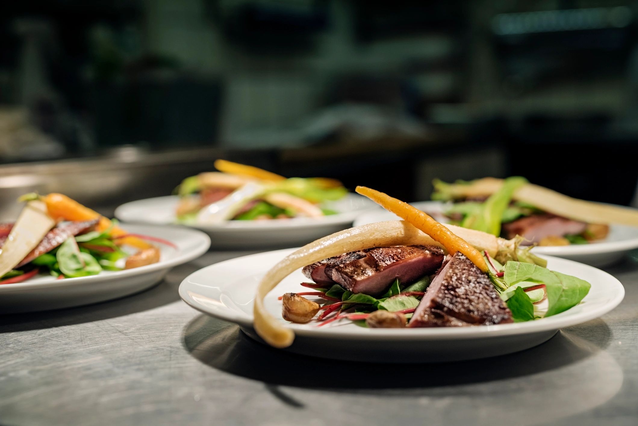 Plated duck breast dish in a restaurant setting