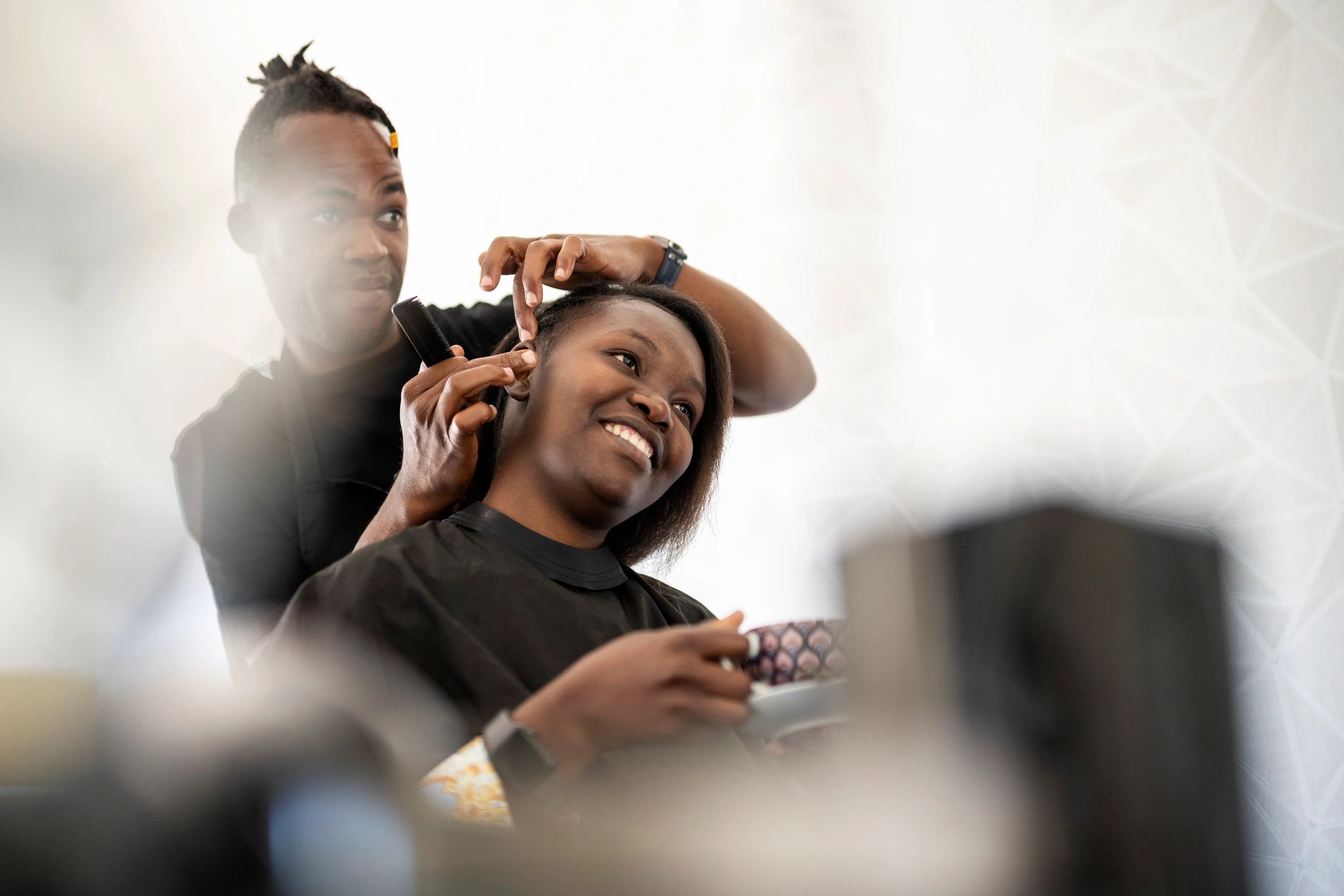 Hairdresser showing a finished hairstyle to a salon client
