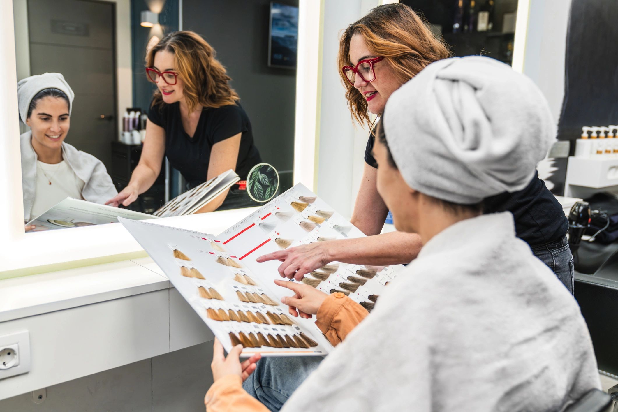 Stylist consulting with a client about hair color options in a salon